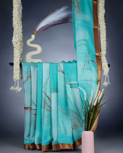 Muslin Silk Saree With Abstract Print Complimentedly A Golden Zari Border - Blue